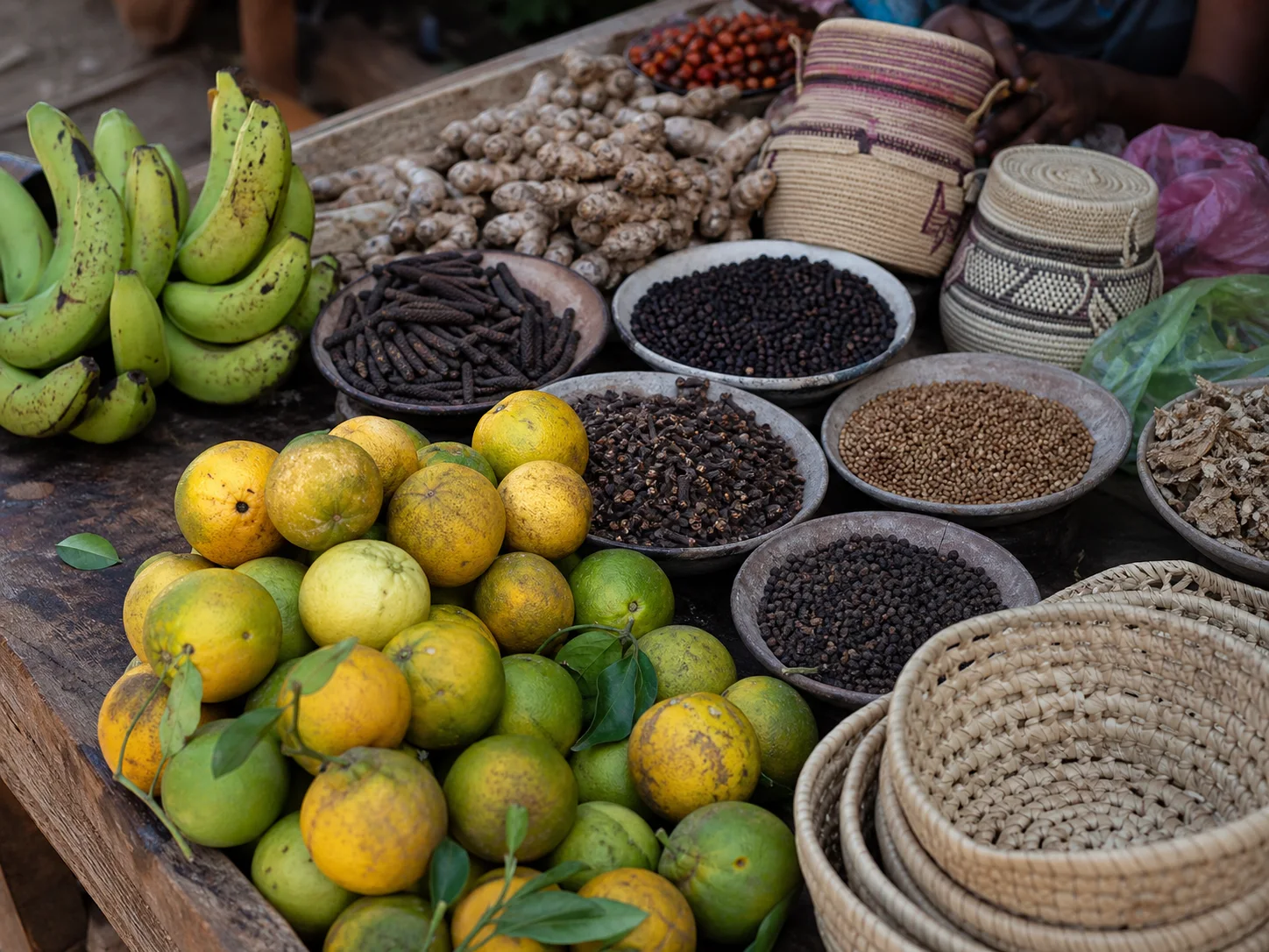 Fruits tropicaux, épices en vrac et vannerie disposés sur un étal de marché