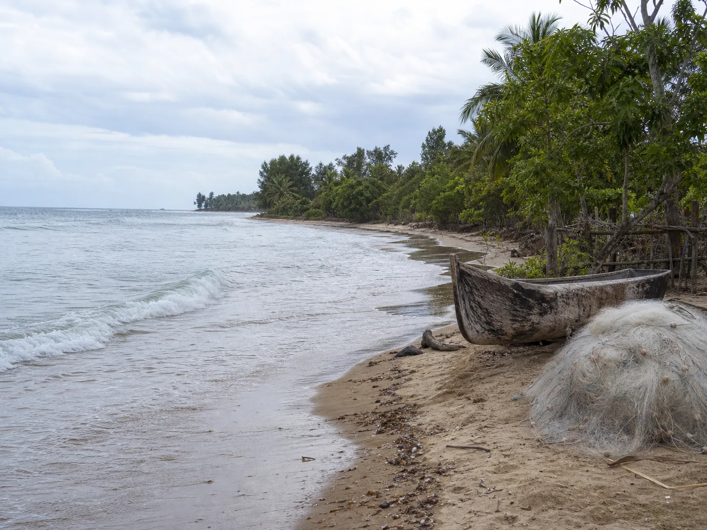 Pirogue et filet posés sur le sable au bord de l’océan
